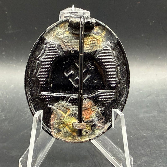 Reverse of black wound badge with flatwire catch and wrap-around hinge