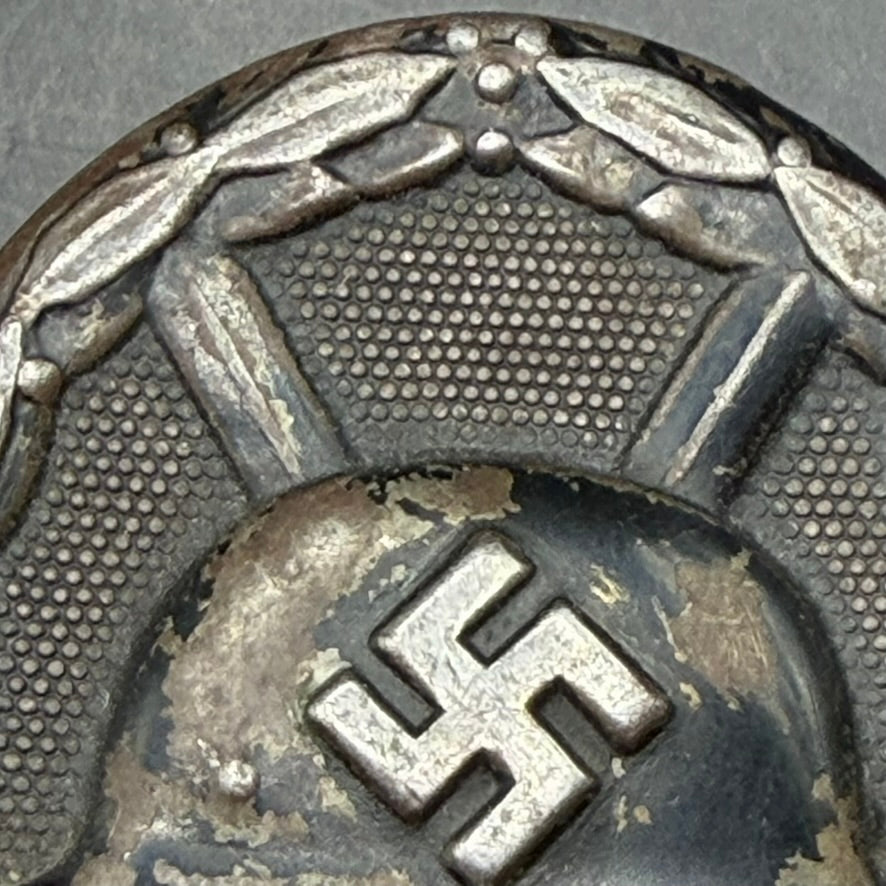 Macro view of surface wear and zinc base metal on WWII German Wound Badge in Black