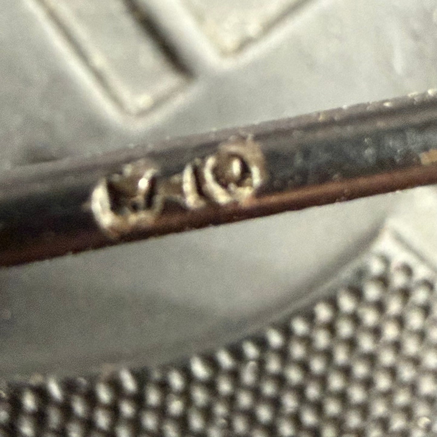 Macro detail of L/18 stamped into the pin