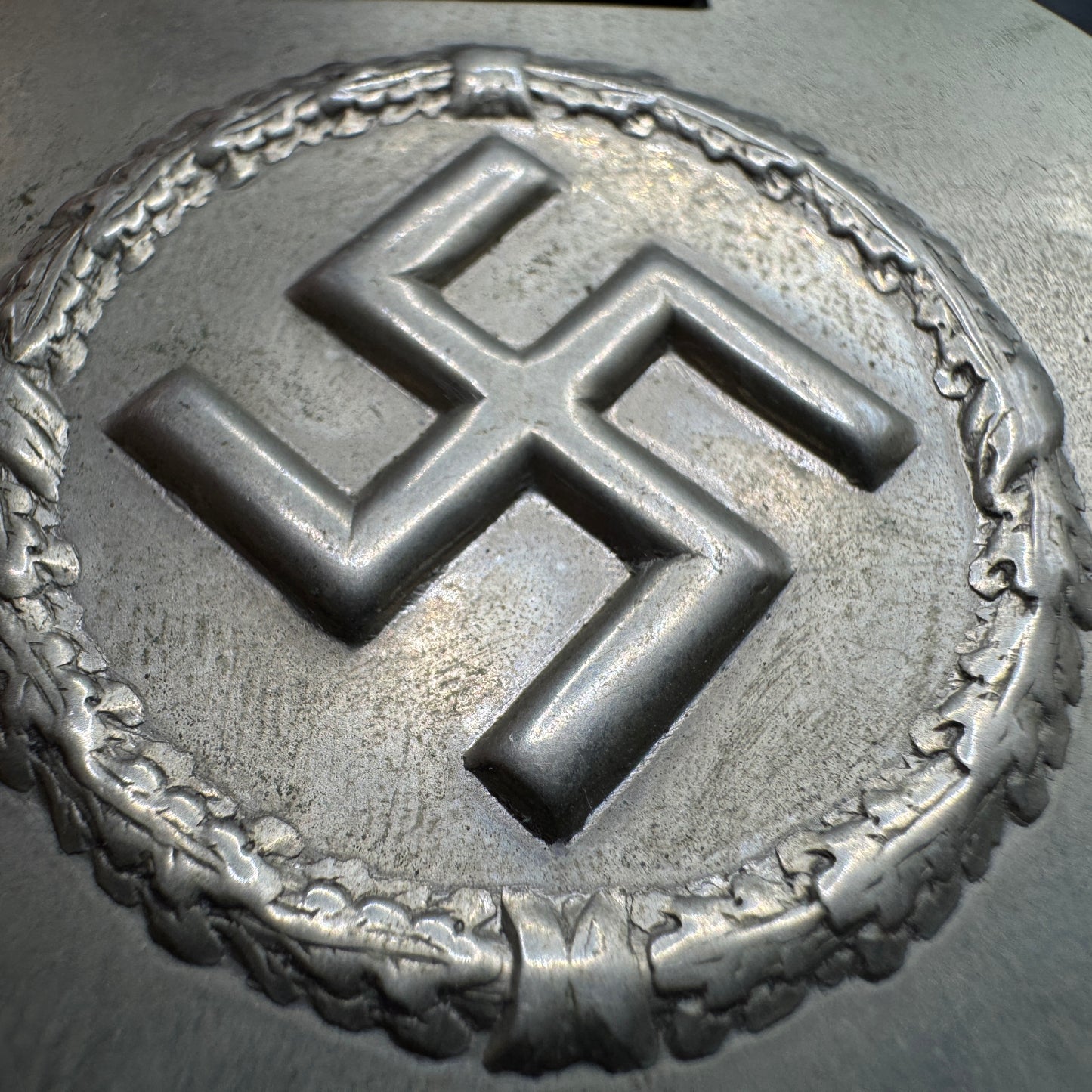 WW2 original artifact – WWII-era German metal swastika mounted on leather – interior title page