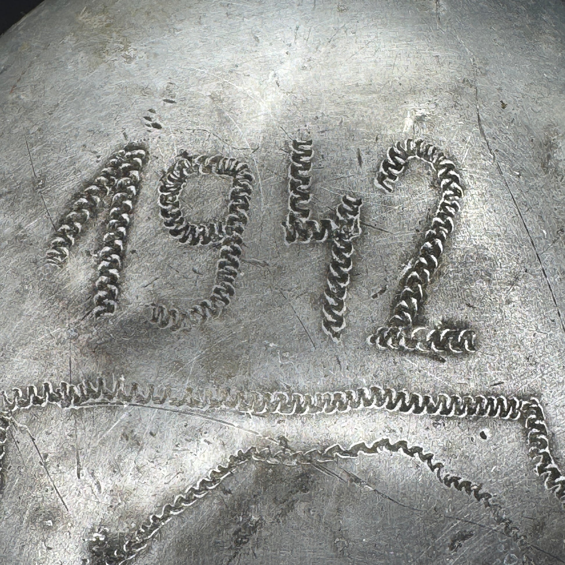 Close-up showing engraved year “1942” on WWII German canteen, part of original trench art
