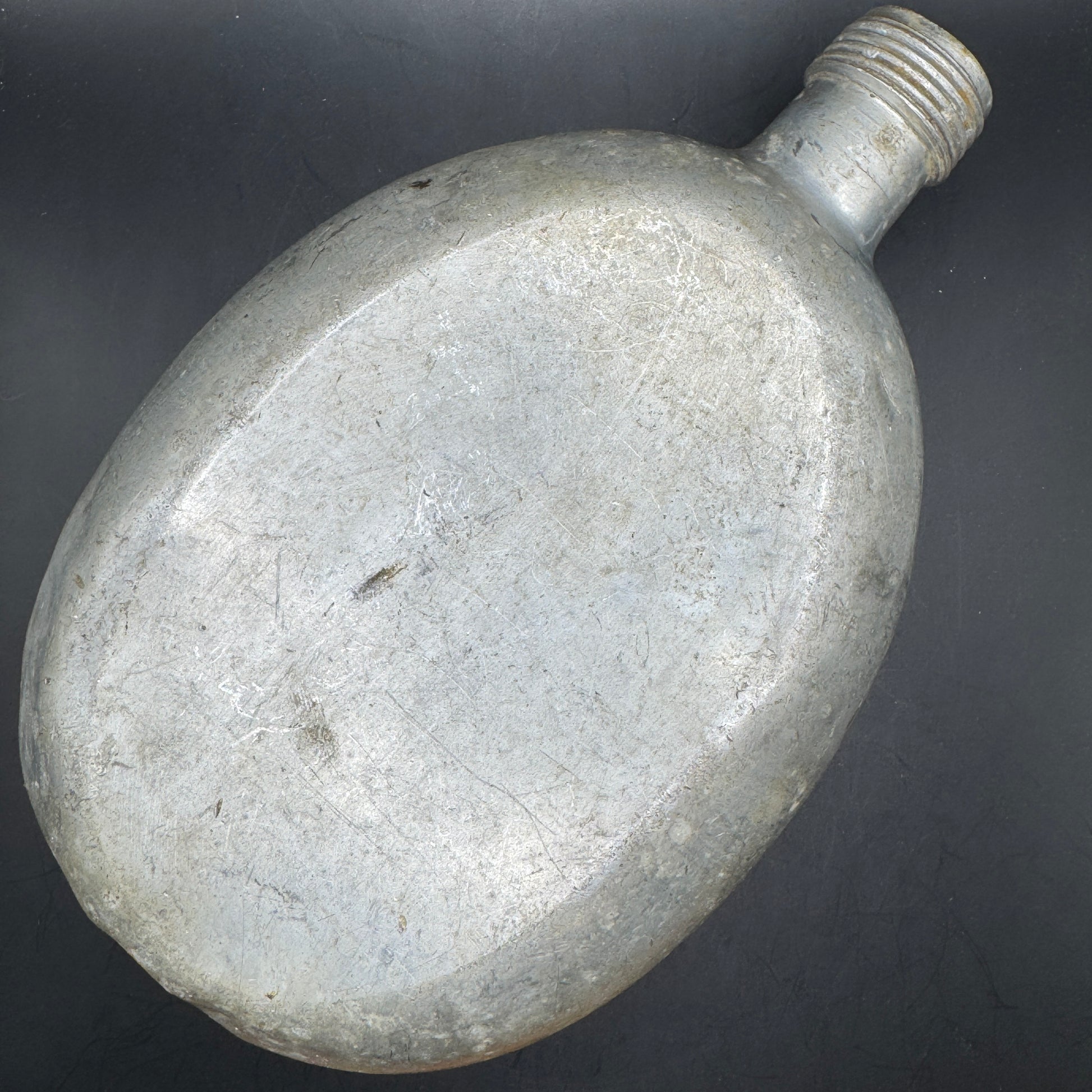 Rear view of original WWII German aluminum canteen showing wear and patina from field use