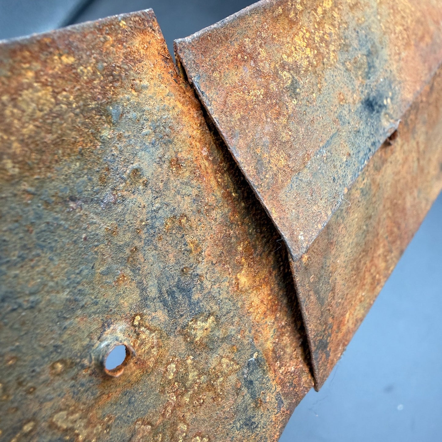 Close-up of original mounting hole on WW2 SS Wiking direction sign with aged steel surface