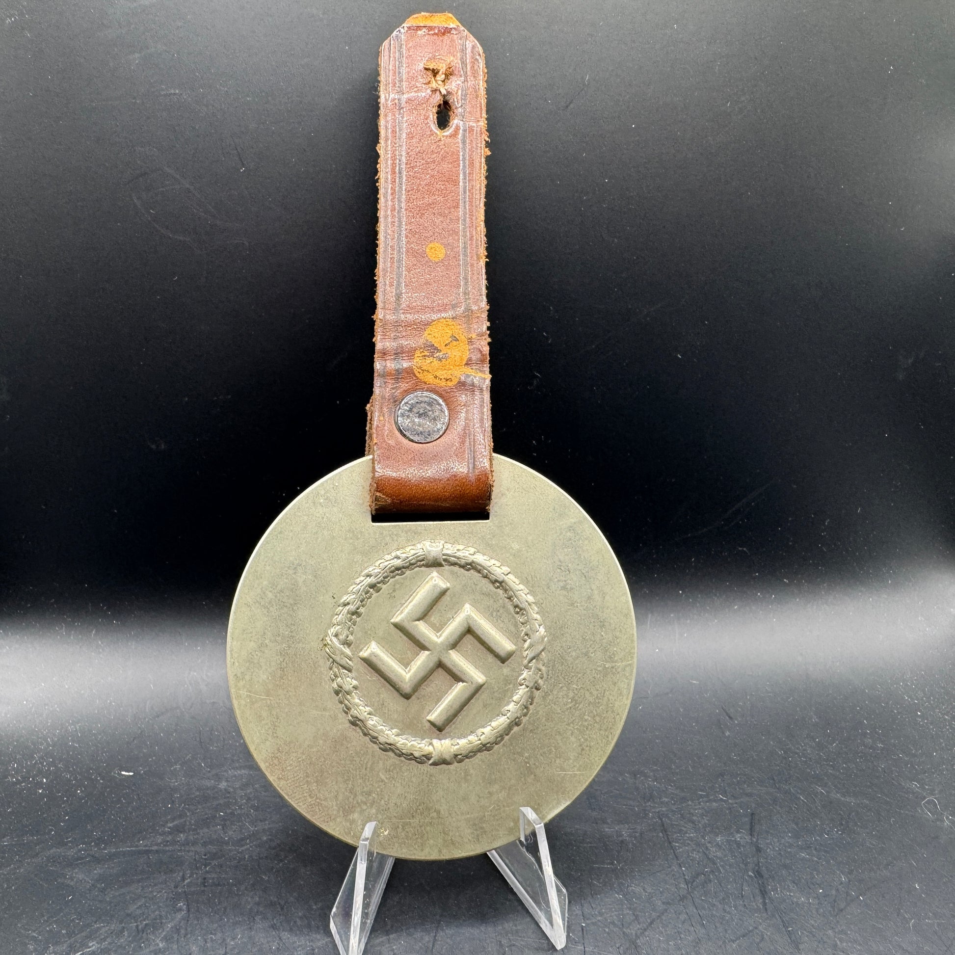 WW2 original artifact – WWII-era German metal swastika mounted on leather – AxisArtifacts