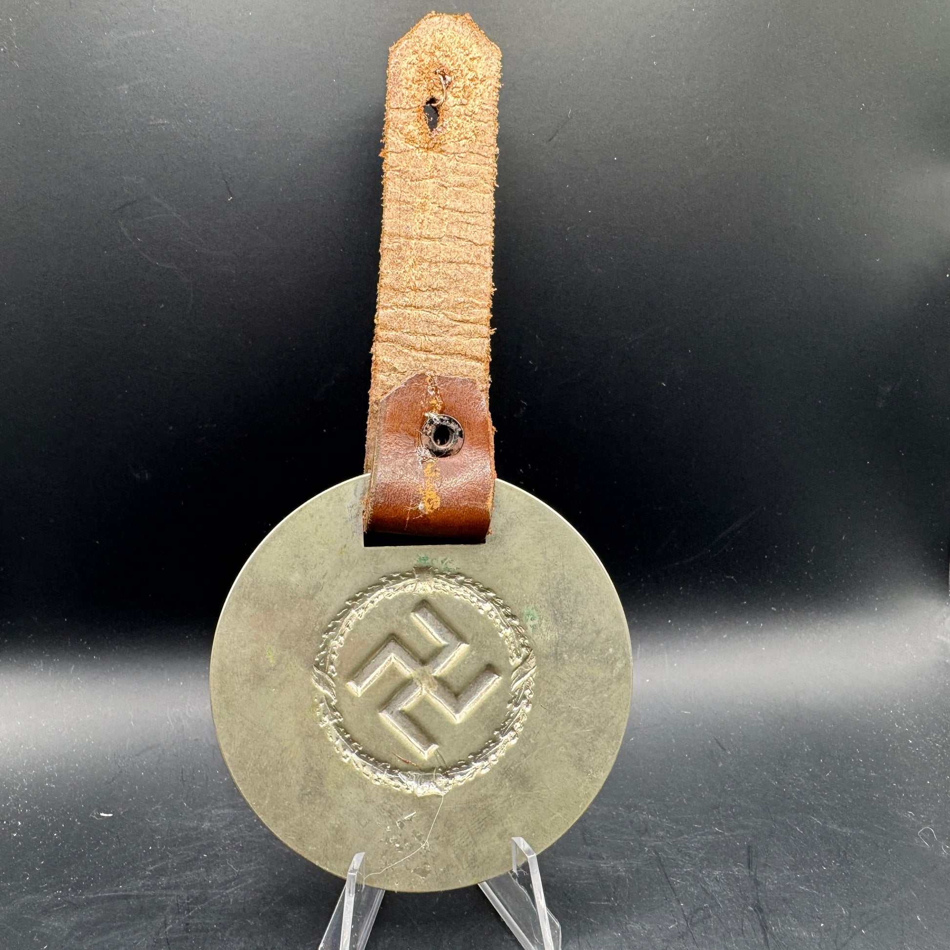 WW2 original artifact – WWII-era German metal swastika mounted on leather – interior detail