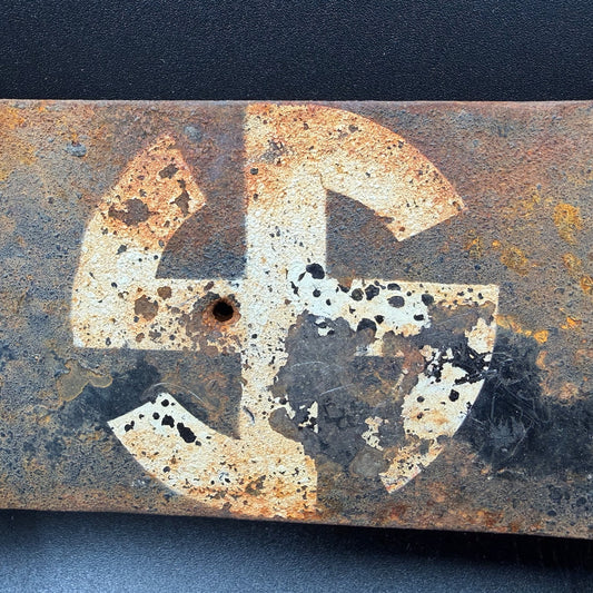 Close-up of original SS Wiking symbol on WW2 German directional sign, showing aged paint and corrosion