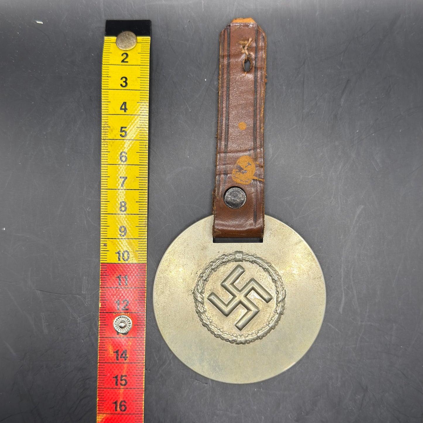 WW2 original artifact – WWII-era German metal swastika mounted on leather – interior page