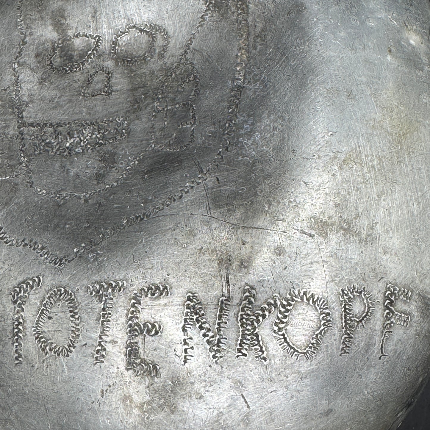 Close-up of engraved SS Totenkopf motif on WWII German canteen with period trench art