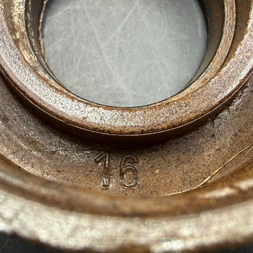 Close-up of cap rim with stamped marking “16” and original patina