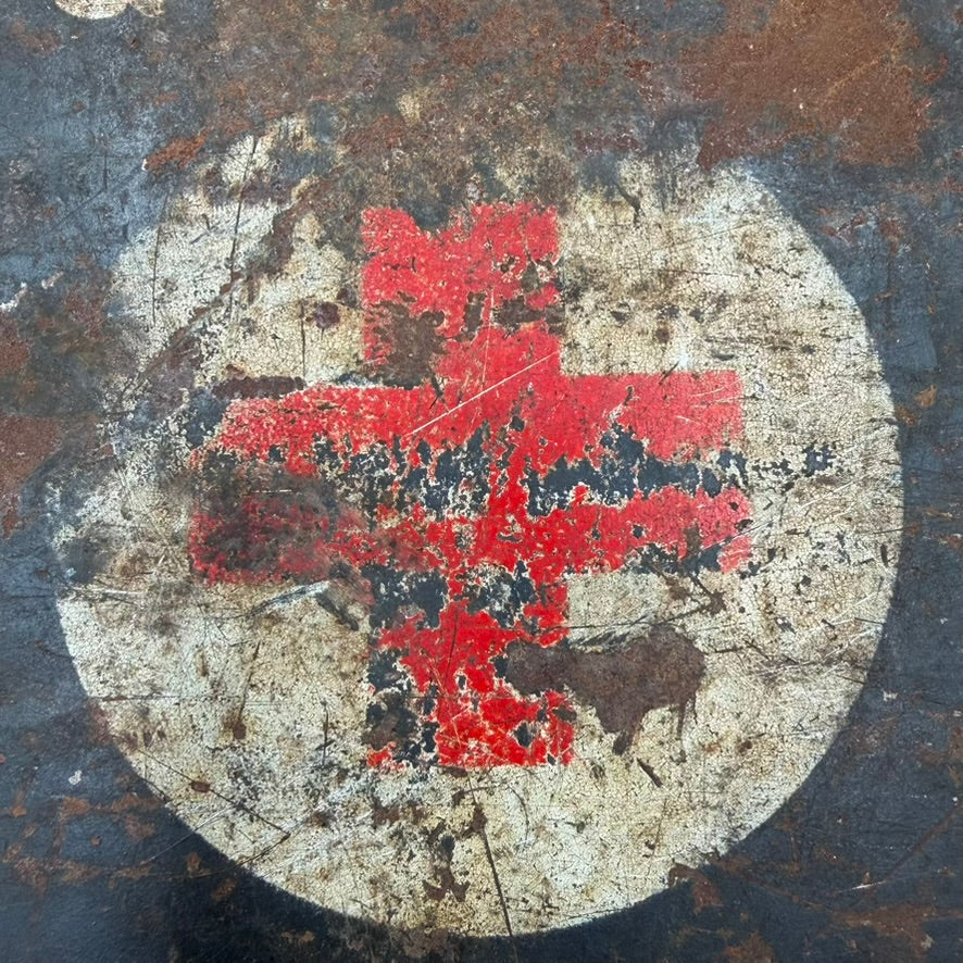 Detail of Red Cross emblem with worn wartime paint and patina