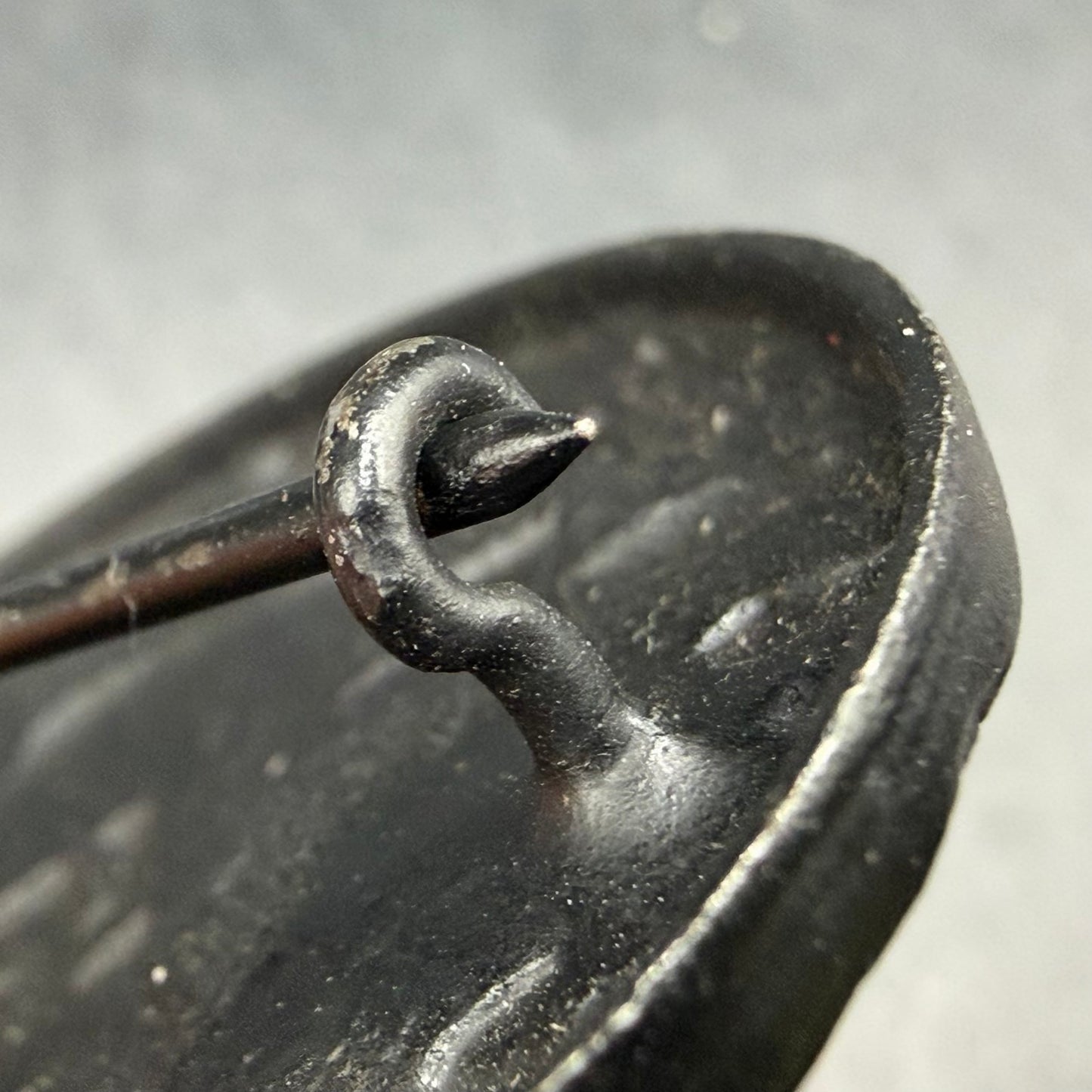 Rear view showing iron question mark catch on black wound badge