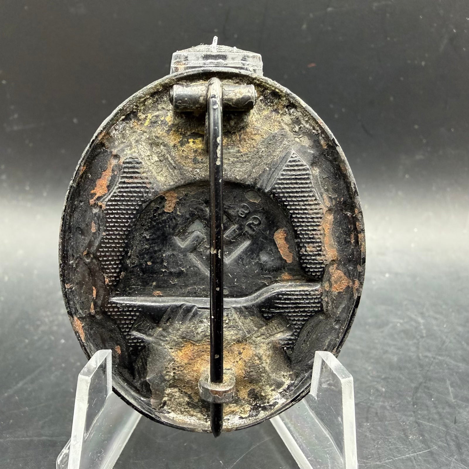 Reverse of iron wound badge showing flatwire catch and wrap-around hinge