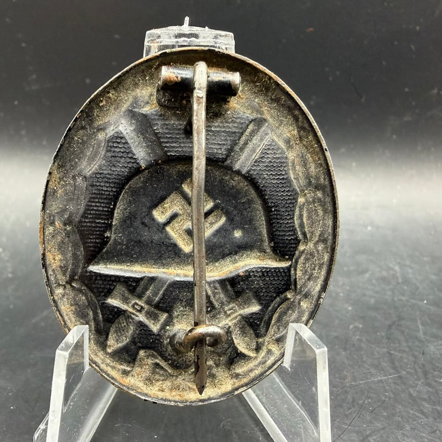 Reverse of WWII German zinc Wound Badge showing wrap-around sheet metal hinge and question