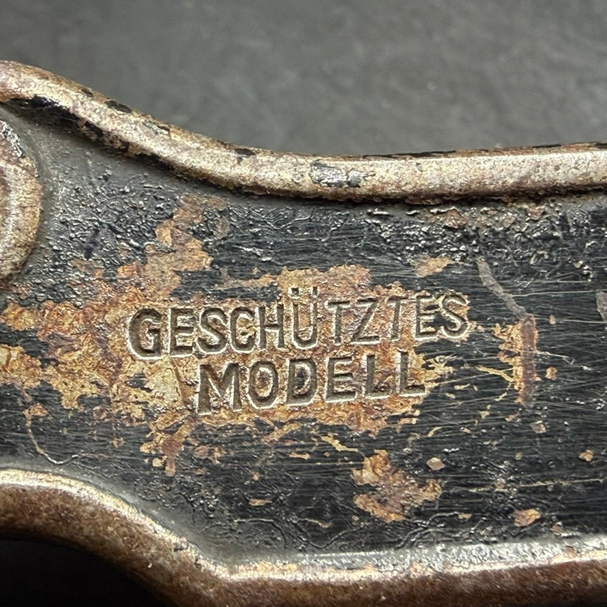 Close-up of Geschütztes Modell marking on German pre-WWII can opener