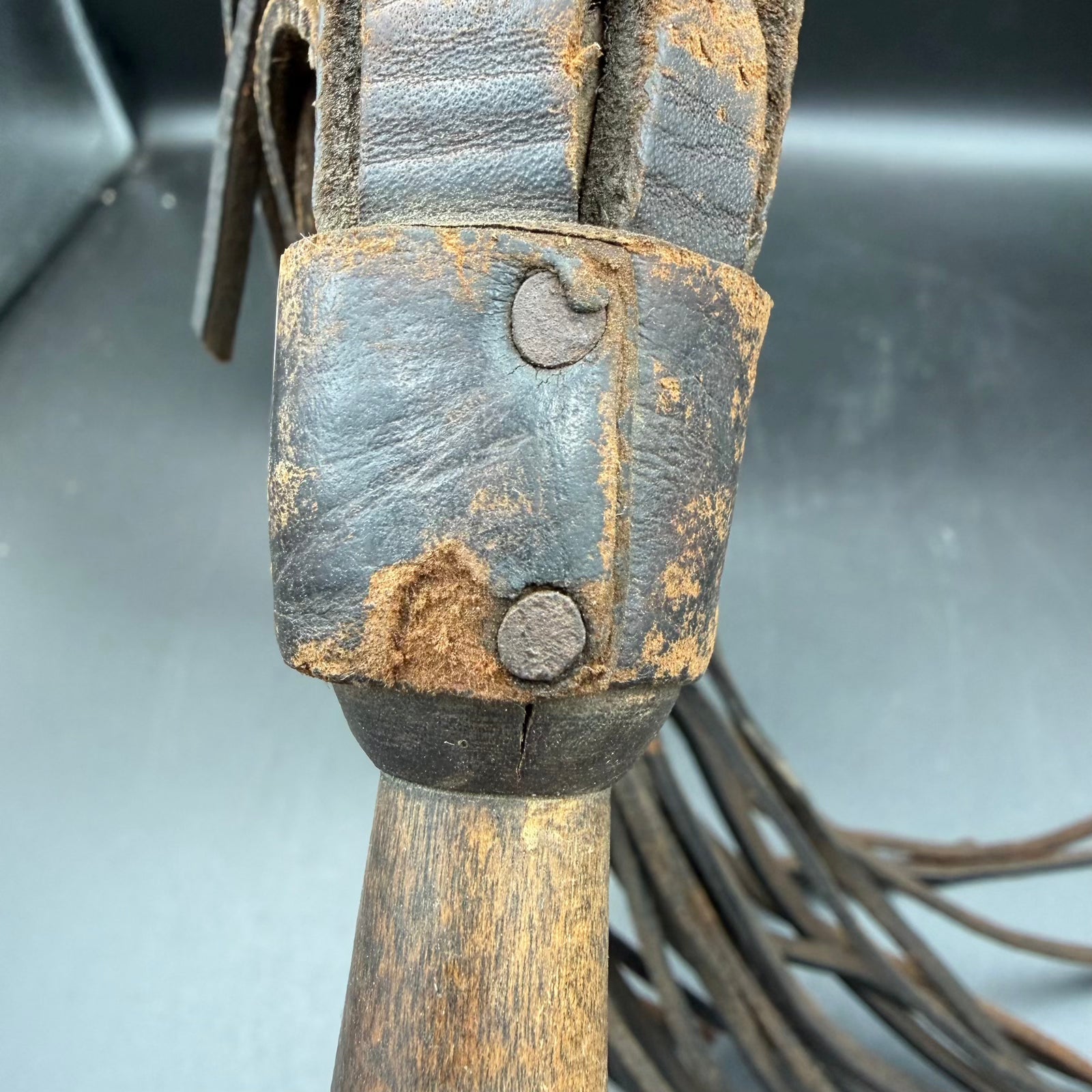 Close-up of wooden handle showing lanyard hole and wartime patina