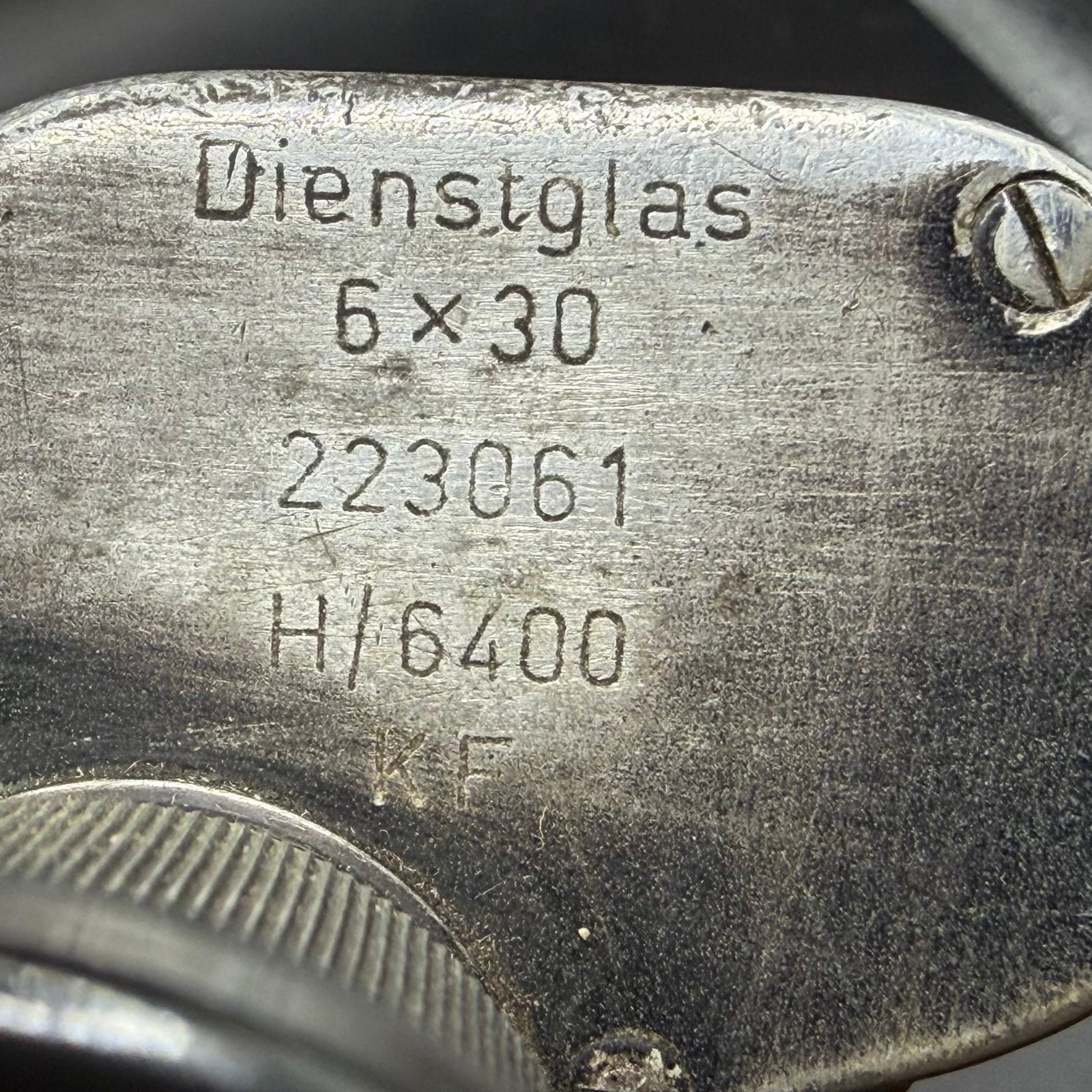 Close-up of wartime markings on German Dienstglas 6×30 binoculars, showing eso manufacturer code, serial number and H/6400 specification.