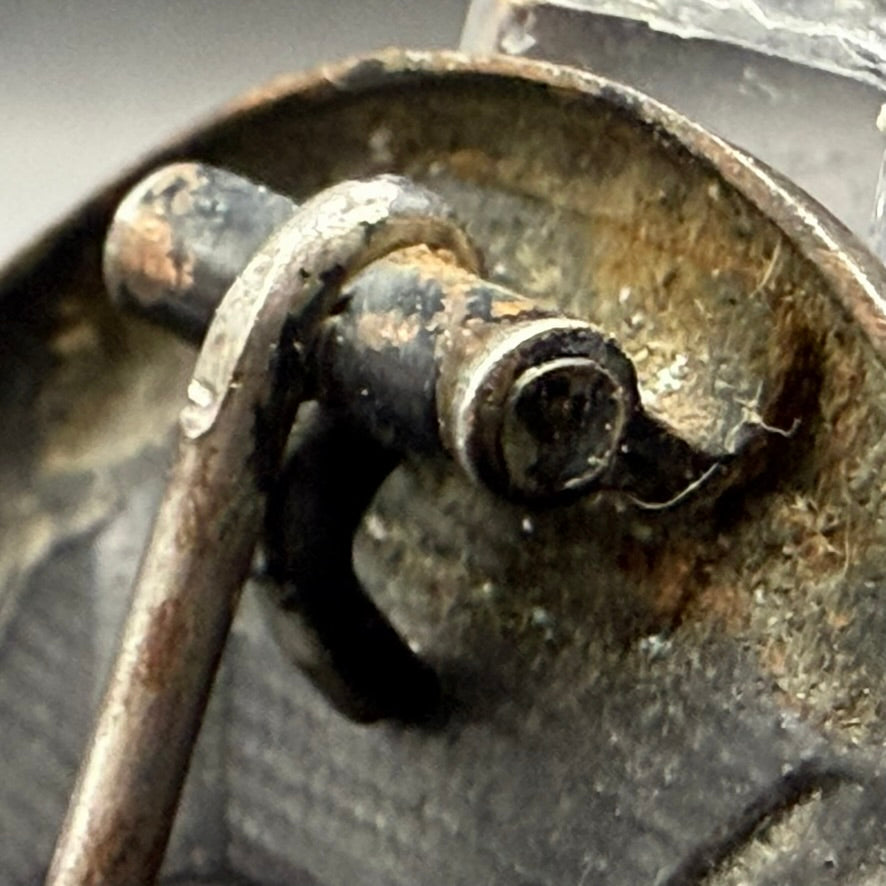 Close-up of wrap-around sheet metal hinge on WWII German zinc Wound Badge