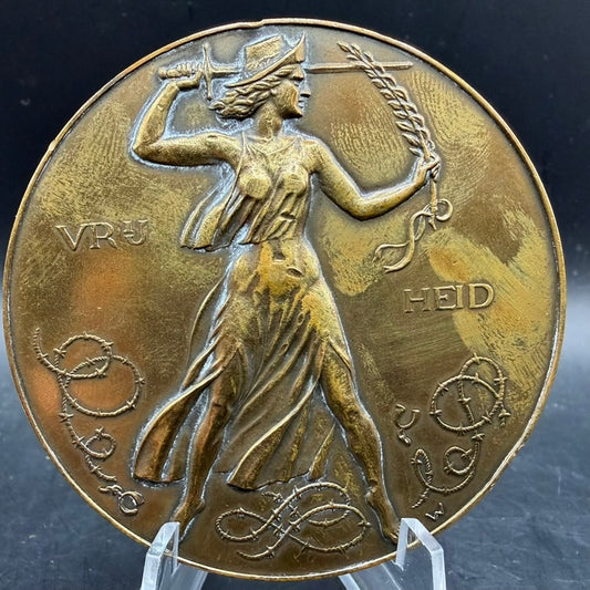 Large bronze liberation medal May 5 1945, female allegorical figure with sword and wheat, inscription “Vrijheid”, barbed wire motif.