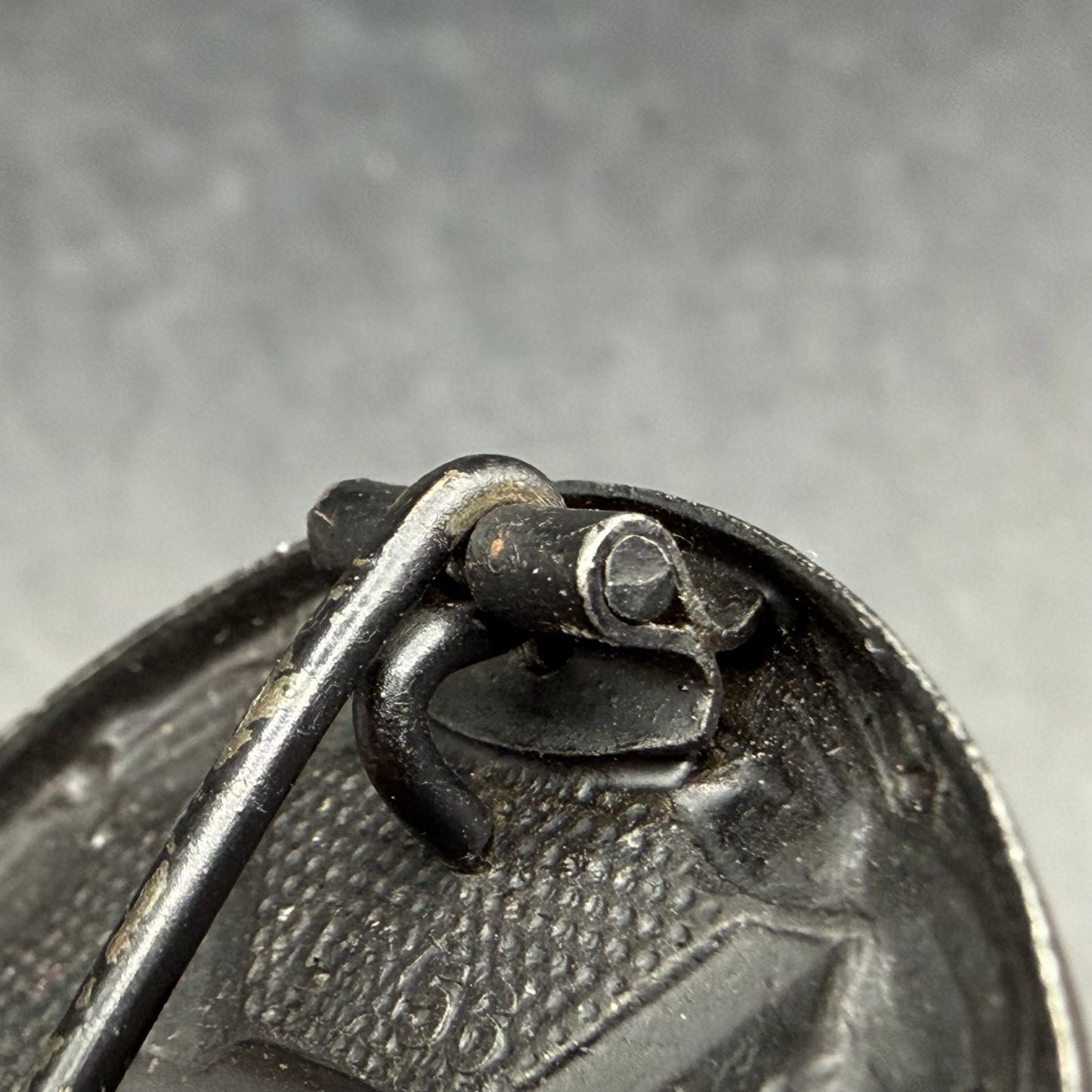 Close-up of oval sheet metal hinge on L/56 wound badge