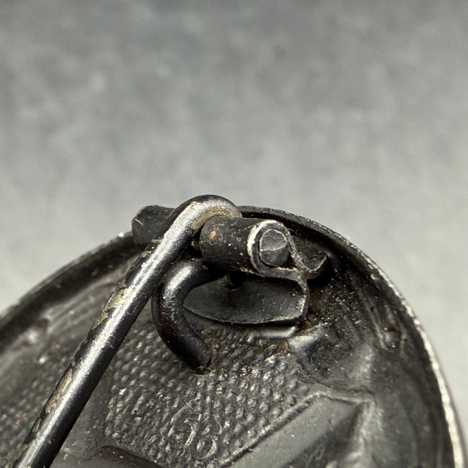 Close-up of oval sheet metal hinge on L/56 wound badge