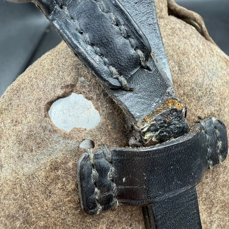 Detail of leather retaining strap on WW2 German canteen, showing tear but still firmly attached