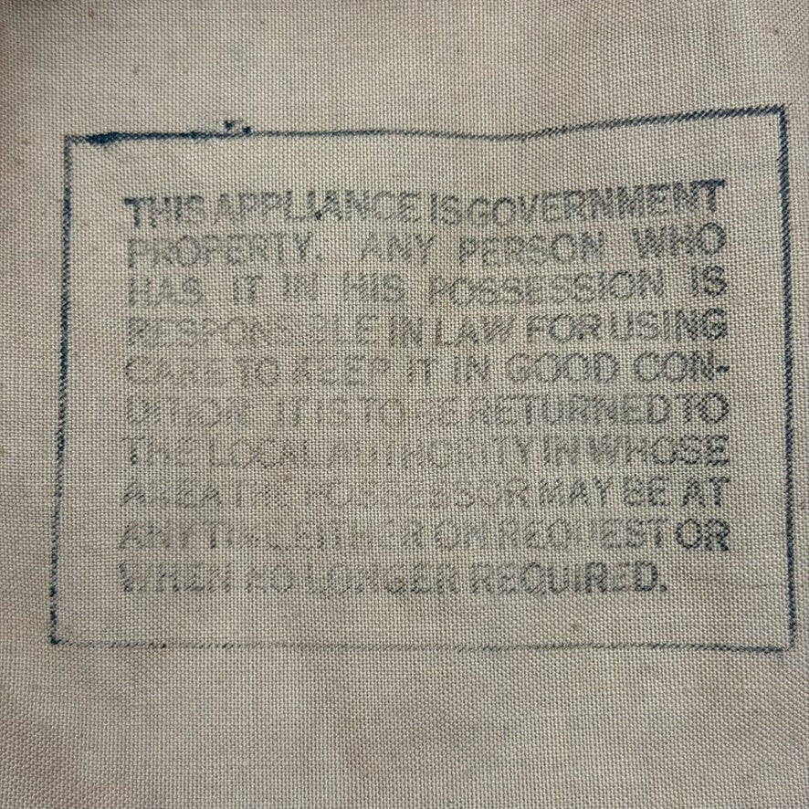 Wartime warning text stamped on canvas hood of British Hospital Respirator gas mask, World War II